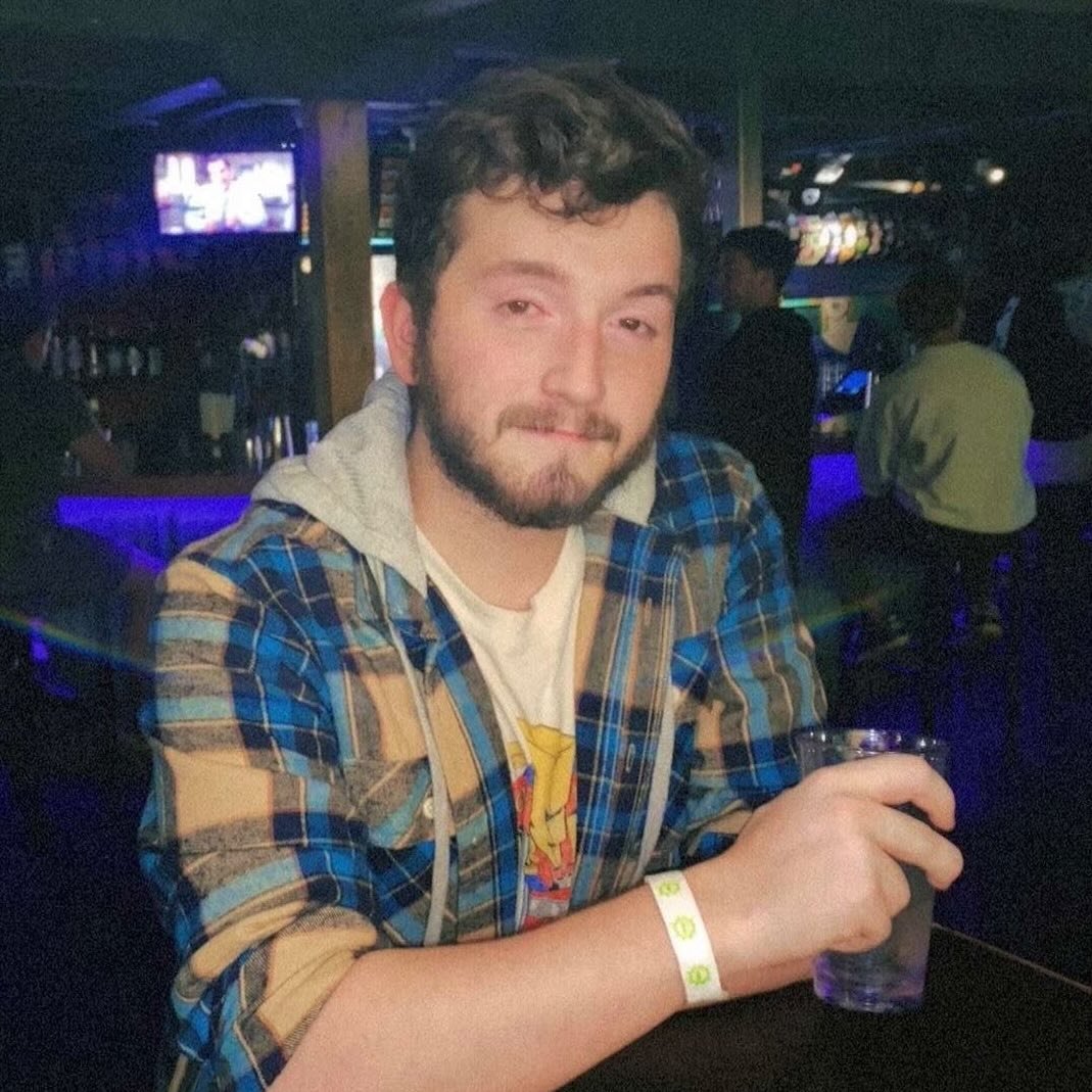 Hands chopping fresh herbs and garlic on a wooden cutting board, bowls of ingredients nearby