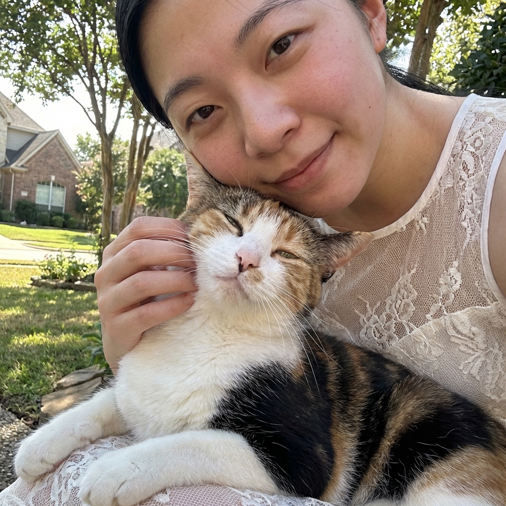 A person gently petting a cat on the cheek while the cat looks relaxed